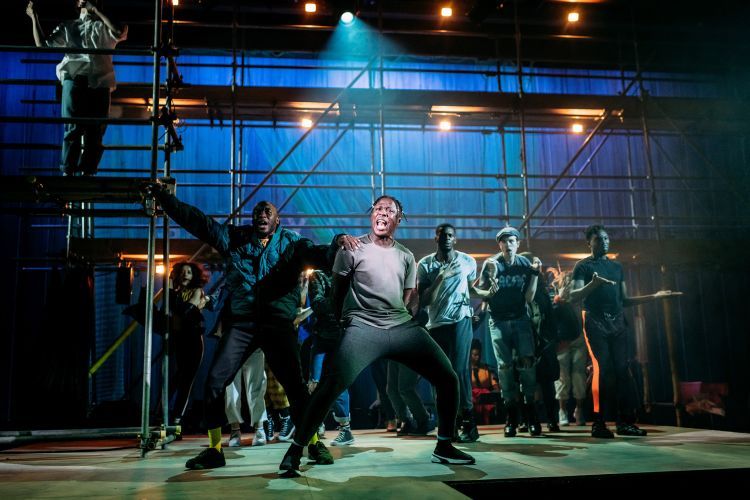 Actors dancing boisteriously on stage